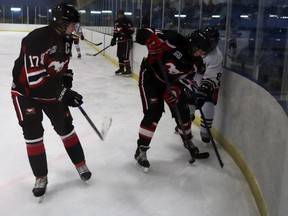 Mustangs Parker Arnell and Parker Hughes cornered Wolverines player Ethan Nisbet to take the puck during a U18 Minor Hockey game at the Mayerthorpe Exhibition Centre Friday.