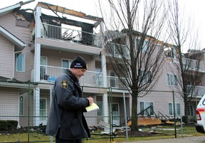 Mike Bird, an investigator with the Ontario Fire Marshal's office, makes notes Tuesday while standing near Fairwinds Lodge retirement home, which was heavily damaged by a fire overnight Monday.  (Terry Bridge/Sarnia Observer)