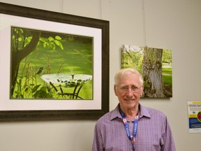 John Robinson stands next to a photo he took in his backyard last summer while participating in the Alzheimer Society of Huron Perth's photography program. The photo along with others shot by local Alzheimer society clients are on display as part of the Capture the Moment exhibit at the Stratford Public Library until Feb. 18. (Galen Simmons/The Beacon Herald)