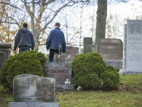 Campbell Monument crew members walk along monuments in Mount Evergreen Cemetery where, so far, a total of 46 headstones were spray painted with graffiti in Quinte West. ALEX FILIPE FILE