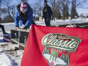 Skaters tie on their skates on the Batawa community Centre ice rink in front of a Pond Hockey Classic jersey. ALEX FILIPE