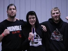 Lucas George (from left to right), Ayden Foster, and Michael Parker take a celebratory photo following Foster's victory at Silver Gloves in Medicine Hat. Humble Boxing Academy sent five athletes to the tournament, each going undefeated.