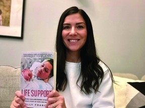 Local author Holly Frances holds up a copy of her new book "Life Support". (supplied)
