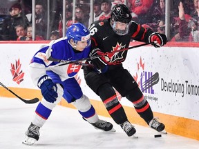 Josef Kumic (6) zo Slovenska a Conor Bedard (16) z Kanady korčuľujú po puku počas druhej tretiny štvrťfinále majstrovstiev sveta 2023 IIHF juniorov v Scotiabank Center 2. januára 2023 v Halifaxe, Severná Amerika (Foto od Minas Panagiotakis/Getty Images)