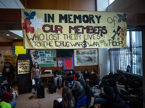 Laura Shaver, back left, speaks at a gathering to remember those who died from a suspected illicit drug overdose in Vancouver on Feb. 9, 2022.
