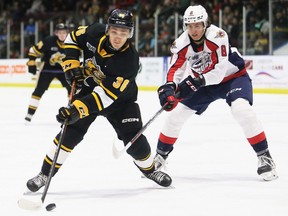 Sarnia Sting's Sasha Pastujov (36) protects the puck from Windsor Spitfires' AJ Spellacy (8) in the first period at Progressive Auto Sales Arena in Sarnia, Ont., on Friday, Jan. 6, 2023. Mark Malone/Chatham Daily News/Postmedia Network