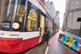 A woman boards a street car through the financial district in Toronto, Ontario, on January 5, 2022. (Photo by GEOFF ROBINS/AFP via Getty Images)