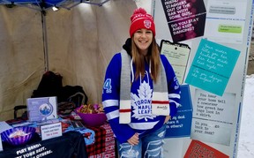 Manajer program Rumah Wanita Marcy Stocking memasuki semangat Hari Hoki di Kanada dengan mengenakan kaus Toronto Maple Leafs dan toque Hari Hoki di stan agen layanan dukungan kekerasan seksual Sabtu, 21 Januari 2023 di Owen Sound, Ont.  (Scott Dunn/The Sun Times/Jaringan Postmedia)