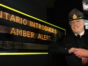OPP Insp. Alex Kehoe is shown in this Dec. 21, 2005, file photo next to a Ministry of Transportation electronic highway message sign displaying an Ontario Amber Alert for the public