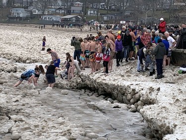Participants in Port Dover's annual Polar Bear swim carefully making their way in to the ice waters of Lake Erie on Sunday. Icy conditions along the beach forced the swimmers to get into the lake from a different location.