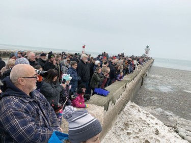 Hundreds of people line the Port Dover pier for the annual New Year's Day polar bear swim. Icy conditions along the beach prevented participants from running in and out of Lake Erie. So, they went to a location closer to the pier and took turns plunging into the lake.