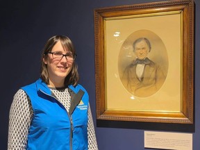 Brockville Museum curator/director Natalie Wood poses with a portrait of William Buell Jr. created by artist Frederick William Lock, one of several works by Lock on display in the museum's latest exhibit. (SUBMITTED PHOTO