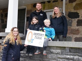 The Schreuders family of Fullarton received a Century Farm sign from Jolande Oudshoorn, of Nile, the past president of the Huron-Perth Junior Farmers Jan. 21. Derek and Danielle Schreuders, and their children Chloe, 7; and Parker, 4, were happy to designate their farm in the program, which has been going for well over 50 years. The farm has been in Danielle's family - the Walkoms - for generations. ANDY BADER/MITCHELL ADVOCATE