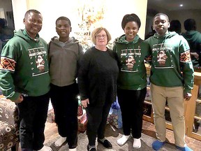 Vincent Suh, left, and his family, including son Deshawn, 13, second left, wife Lem and son Dajuan, 16, are seen her with Kathy Vandergriendt during their unexpected stay in Ridgetown after being stranded during a severe winter storm that hit the area just before Christmas.  PHOTO handout