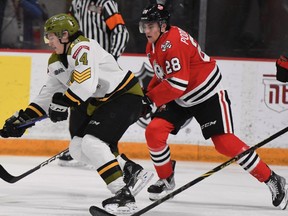 Dalyn Wakely of the North Bay Battalion skates against Michael Podolioukh of the host Niagara IceDogs in Ontario Hockey League action Saturday night. The Troops complete a weekend road trip Sunday night against the Oshawa Generals.