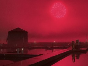 Confederation Basin glows red from the light of the New Year's Eve fireworks in the thick fog over Kingston, Ont. on Saturday, Dec. 31, 2022.