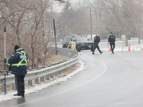 Members of the OPP Technical Collision Investigation and Reconstruction Unit work at the scene of a crash outside Amherstview, where a vehicle left the road and went into Lake Ontario at the corner of Bath Road and County Road 6 on Friday.