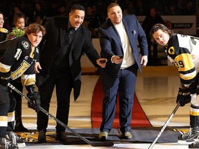 Anthony Stewart, left, and his brother Chris, both former Kingston Frontenacs, drop the ceremonial puck before a game between the Frontenacs and Hamilton Bulldogs on Jan. 14. On the left is Frontenacs captain Paul Ludwinski, with Hamilton’s Lawson Sherk on the right.