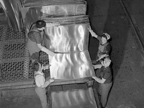 Women workers at Kingston's Aluminum Company of Canada plant stack sheets of aluminum on a platform for the annealing furnace in January 1943.
