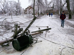 Pedestrians walk past a downed hydro transformer during the first day of the 1998 ice storm in Kingston on Thursday, Jan. 8, 1998.