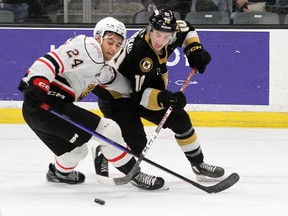 Kingston Frontenacs forward Chris Thibodeau tries to get to the puck past Owen Sound Attack's Taos Jordan in Ontario Hockey League action at the Leon's Centre in Kingston on Friday, Jan. 6, 2023.