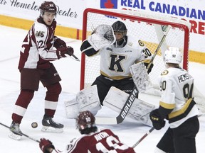 Peterborough Petes' J.R. Avon fires the puck at Kingston Frontenacs goaltender Ivan Zhigalov as centre Tucker Robertson skates into position during first-period Ontario Hockey League action on Saturday, Jan. 7, 2023, in Peterborough.