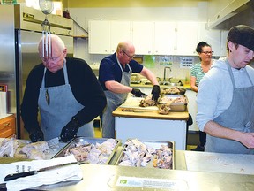 Photo by KEVIN McSHEFFREY
On Christmas Eve, more than 30 volunteers were preparing the meals for the Berghammer Christmas Dinner at the Collins Hall on Dec. 25. The volunteers in the photo, Gus Coderre, Simon Gregory, William Elliott and Laura Paradis, were carving the turkeys for the Christmas dinner. Other volunteers were peeling potatoes, slicing onions and more.