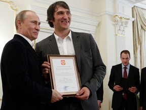 (FILES) In this file photo taken on May 29, 2012, Russian President Vladimir Putin (R) holds a certificate, along with Russian national ice hockey team member Alexander Ovechkin (2nd L), thanking Ovechkin for his efforts to help Russia win the 2012 World Championship.
