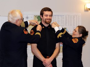 Newly promoted firefighter AJ Penner, the center received his badges from Fire Chief Randy Schroeder and Captain Angela Schroeder.