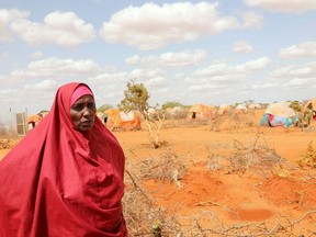 Halima Hassan Abdullahi stands near the graves of her twin granddaughters, Ebla and Abdia, who died of hunger at the Kaxareey camp for the internally displaced people, in Dollow, Gedo region of Somalia, on May 24, 2022.