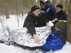 London Search and Rescue held Exercise Frost Bite on Feb. 5, 2011 in the Kinsmen Sugar Bush. The competition pitted volunteer search and rescue teams from around Southwestern Ontario in a competition with several tasks. Simulated victim Trent Martin is being helped by Shane Camelford of Guelph, Paul Lenhardt of London and Michelle McGray of Guelph, who were on a team that had to first find the victim, then perform first aid, and then take him to help. Mike Hensen/File photo/Postmedia