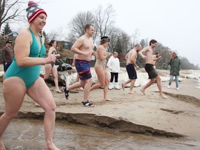 Taryn Barnes, left, and her husband Matt, in sandals, organized a polar dip in Bright's Grove Sunday, raising money for addiction services at Bluewater Health.  (Tyler Kula/ The Observer)