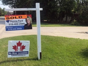 A sold sign featuring realtor Donna Ford is hung above a lawn sign calling for an end to lockdowns. (Facebook)