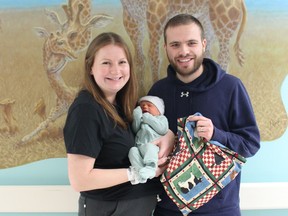 Erika and Kyle McVittie, with their son Luke, are shown with a Baby Bookworm bag at Bluewater Health.