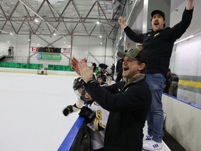 Shea Stokes, left, and Adam Pyne, assistant coaches with the U11 Lambton Jr. Sting, react after the team scores Saturday during Silver Stick action Saturday at the Progressive Auto Sales Arena in Sarnia.