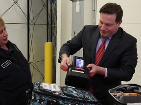 Public Safety Minister Marco Mendicino tries a portable x-ray scanner at the Blue Water Bridge in Point Edward Jan.  17, 2023. Also pictured is CBSA superintendent Sally Craggs.  (Tyler Kula/ The Observer)