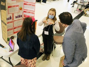 Faye Colborne explains her project Fidget Focus to judge Dave Machacek alongside partner Kaleigh Edmunds, both Grade 4 Errol Village elementary school pupils, during the Lambton County Science Fair at the Dante Club in 2022 in Sarnia, Ont.