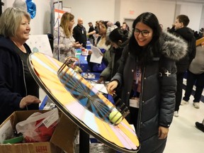 Heather Martin, left, CEO of Vision Nursing Home, watches as Kirti Chuchra spins for a chance to win a prize during a job fair held Wednesday at the Dante Club in Sarnia.
