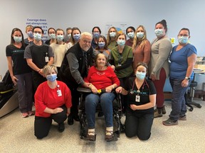 Dan Byelis, stands with his mother, Anica Byelis, surrounded by her care team in Bluewater Health's inpatient rehabilitation unit.  Dan Byelis in a Bluewater Health press release praised the hospital group's "very personal approach" and "remarkable" care after his mother was admitted for stroke last November.  (Handout)