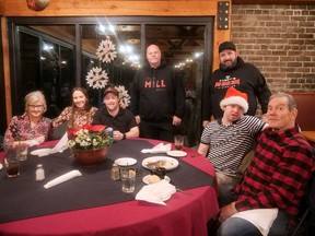 Carolijn Verbakel, from left, Sarah MacNeil, Matthew MacNeil, Gavin Verbakel and John Verbakel are joined by The Mill Inn + Eatery co-owners Les Lonsbary and Patrick McMahon on Dec. 25 during The Mill's second annual Pay-What-You-Can Christmas dinner. CHRIS ABBOTT