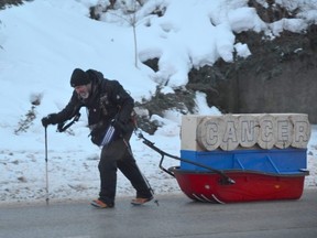 Mike Duhacek climbs the 10th Street East hill in Owen Sound at the start of his Help Me Bury Cancer trek that will take him more than 200 kilometres pulling a more than 200-pound sled with the word CANCER made out of wood on it on Saturday, February 4, 2023.