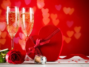 This Valentine’s Day celebration includes champagne, rose, heart-shaped present and red candies.
