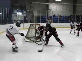 Mustangs goalie Jaxson Moon and John Vanderwell guarded their net from Wolverines player Chester Cowie.