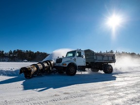 One of the ice road's special clearing vehicles, doing what it does best beneath the majesty of the sun. Photo by Tom Thomson