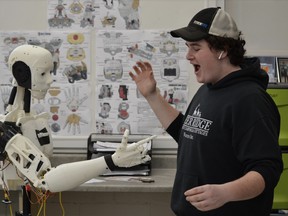 Lasalle Secondary School student Matthew Franklin interacts with Lance the robot.