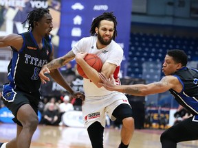 Jeremy Harris (5) of the Sudbury Five shields the ball from KW Titans players Shakwon Barrett and Chad Frazier during NBLC action at Sudbury Community Arena on Monday afternoon. The Five defeated the Titans 107-99.