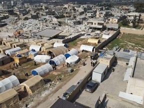 An aerial picture shows the hospital, right, in the town of Harim, near buildings destroyed by an earthquake and tents erected to house homeless residents, in Syria's rebel-held northwestern Idlib province on the border with Turkey on Feb. 11, 2023, in the aftermath of a deadly earthquake. A 7.8-magnitude earthquake rocked Turkey and Syria on Feb. 6, toppling hundreds of buildings and leaving a death toll of at least 3,581 in Syria.