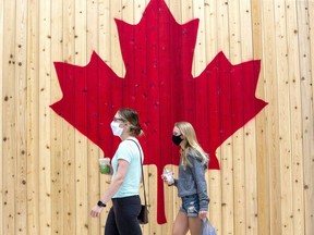 Two sisters walk past the Roots store while shopping at White Oaks Mall in London in July 2020. (Derek Ruttan/The London Free Press)