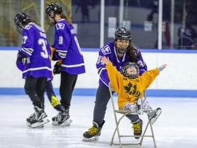 Four-year-old Emily Jennings spreads her wings and flies along the ice thanks to a push from Western Mustangs hockey player Emma Thomas at Thompson Arena in London on Thursday February 9, 2023. Several members of the Mustangs helped out during a blind hockey event for 23 blind or partially sighted Thames Valley District school board students from Kindergarten to Grade 12. (Derek Ruttan/The London Free Press)