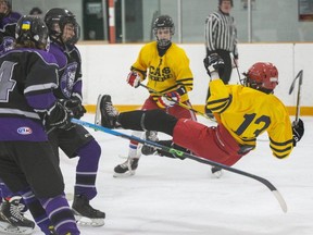 Tyrese Morgan of the College Avenue Knights goes airborne after colliding with Tyler Sweeney of the West Elgin Wildcats in a TVRA boys hockey game at West Lorne Arena in West Lorne on Friday, Feb. 10, 2023. (Derek Ruttan/The London Free Press)